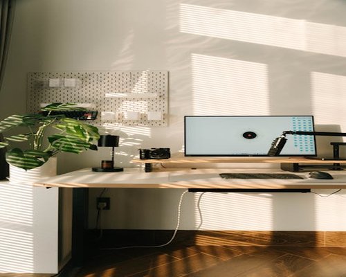 A clean home office setup in Romania with natural light hitting the desk